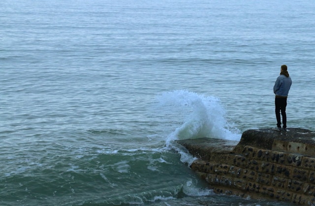 man standing at the edge of the ocean