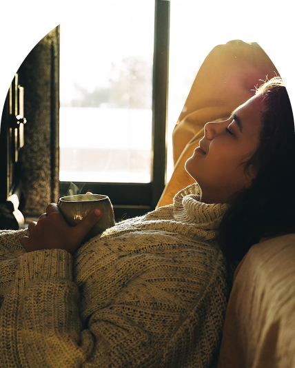 Woman relaxing with a mug of steaming tea.